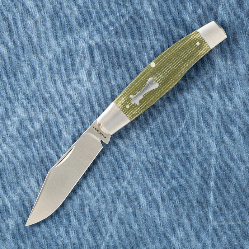 Stainless steel knife with a green textured handle on blue fabric background.