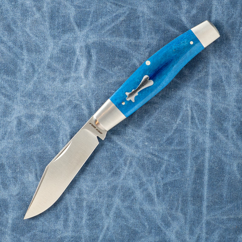 Blue-handled folding knife with a silver blade on a textured blue fabric background, featuring a bone-shaped inlay on the handle.