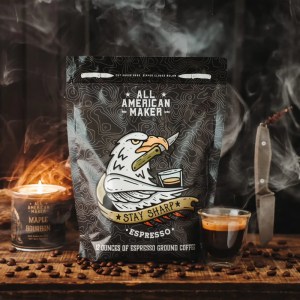 Bag of All American Maker espresso ground coffee featuring a cartoon eagle and a Stay Sharp banner on a dark patterned bag