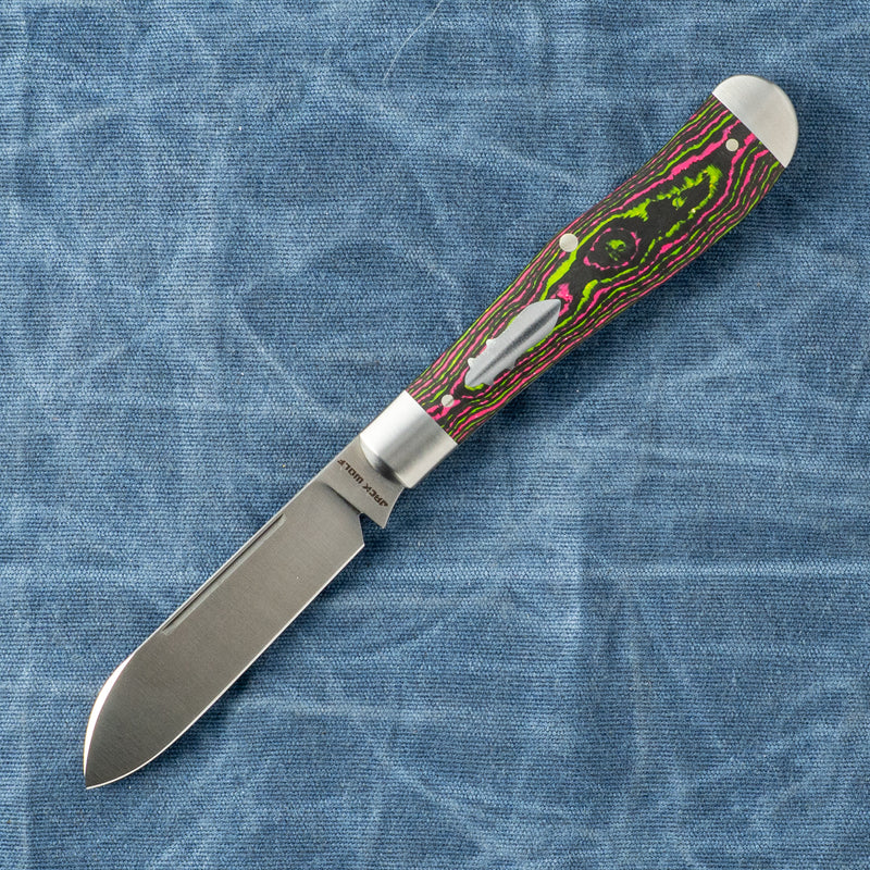 Stainless steel knife with a bright pink-green marbled handle on blue fabric.